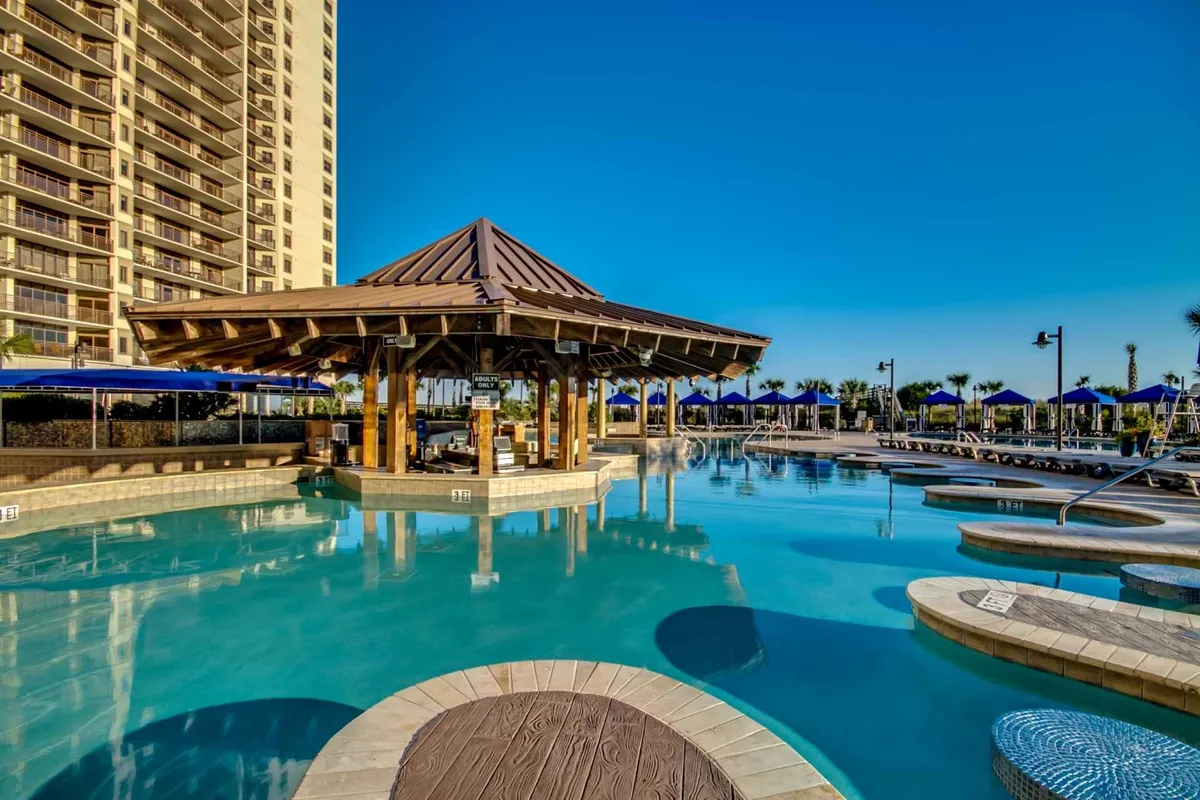 A sunny poolside scene with a swimming pool, inviting lounge chairs, a stylish cabana, and swaying palm trees. The setting is perfect for socializing, sunbathing, or indulging in poolside dining, and it hints at the possibilities for both relaxing and entertaining.